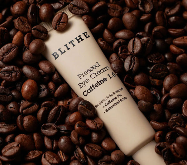 A bottle of Pressed Eye Cream Caffeine 1.0 nestled in coffee beans