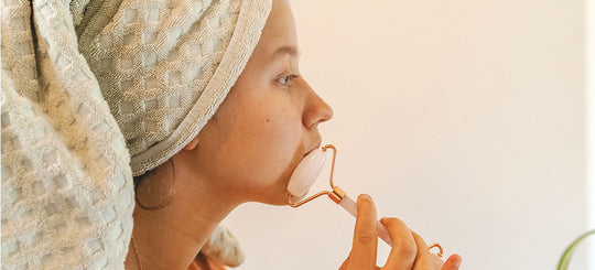An image of a woman gracefully using a face massager on her skin, capturing a moment of self-care and relaxation as she gently enhances her skincare routine with the device.