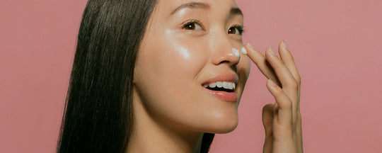Woman applying oil cleanser to her face, starting the double cleanse method.