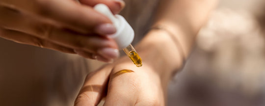 Close-up image of a woman's hand applying serum to her other hand, highlighting the serum's texture and the application process, emphasizing skincare routine and product efficacy.