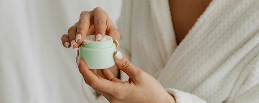 Close-up of a woman applying a calming cream to her skin, highlighting the importance of soothing skincare routines for inflammation.
