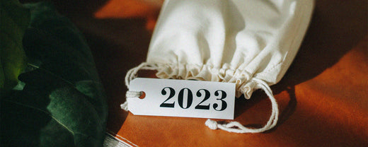 A white fabric bag with a "2023" tag on a warm-toned background, symbolizing new beginnings and fresh starts in skincare trends for the year 2023.