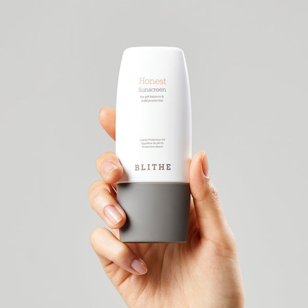  hand holding a bottle of Blithe Cosmetic Honest Sunscreen