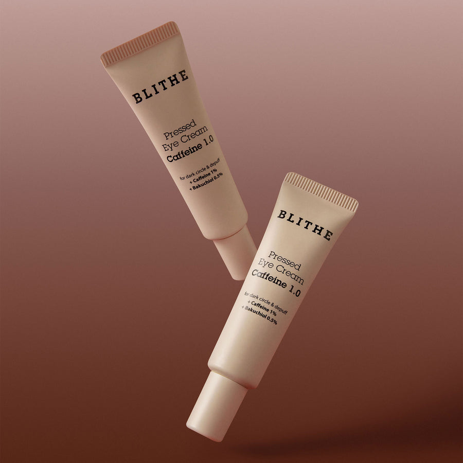 two tubes of Pressed Eye Cream against a brown background