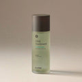 a green VItal Treatment bottle against a beige background